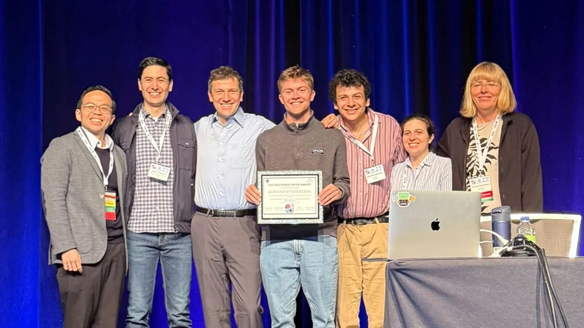 Photo of João, Yuriy, Kyle, Alex, and Emily receiving the award
